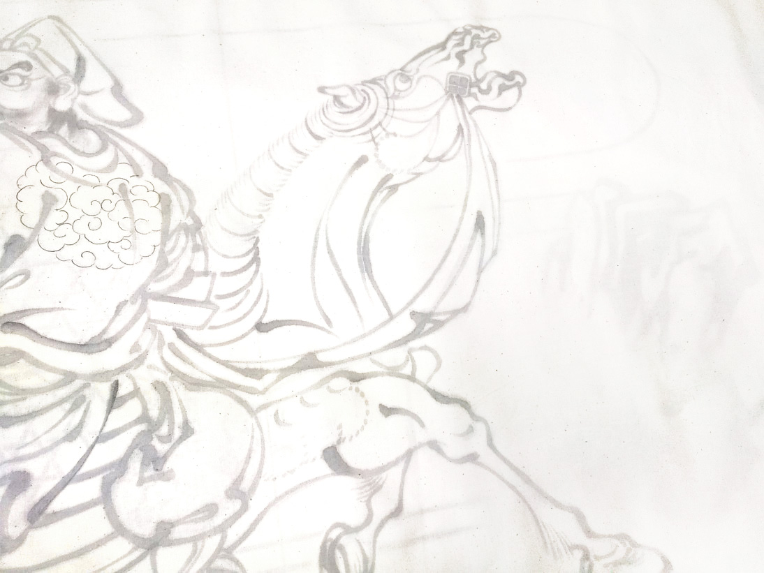 木綿地に人物と馬を描き起こしている水引幕の制作途中