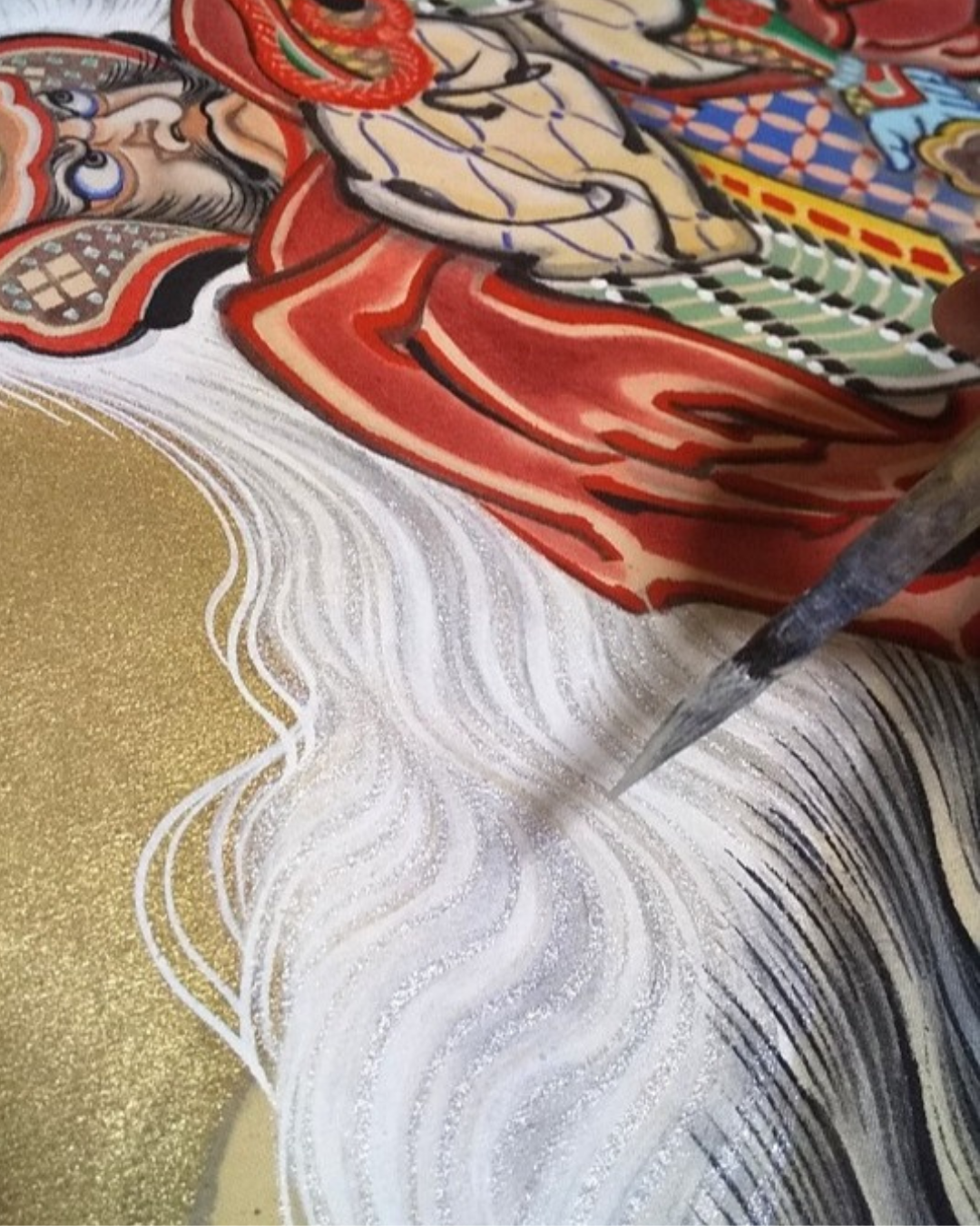 水引幕の馬の毛並みを筆で描き込んでいる制作風景